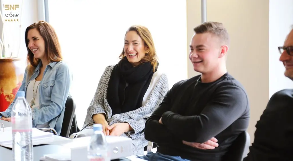 SNF Academy workshop participants laughing during interactive AI coaching session on content creation strategies