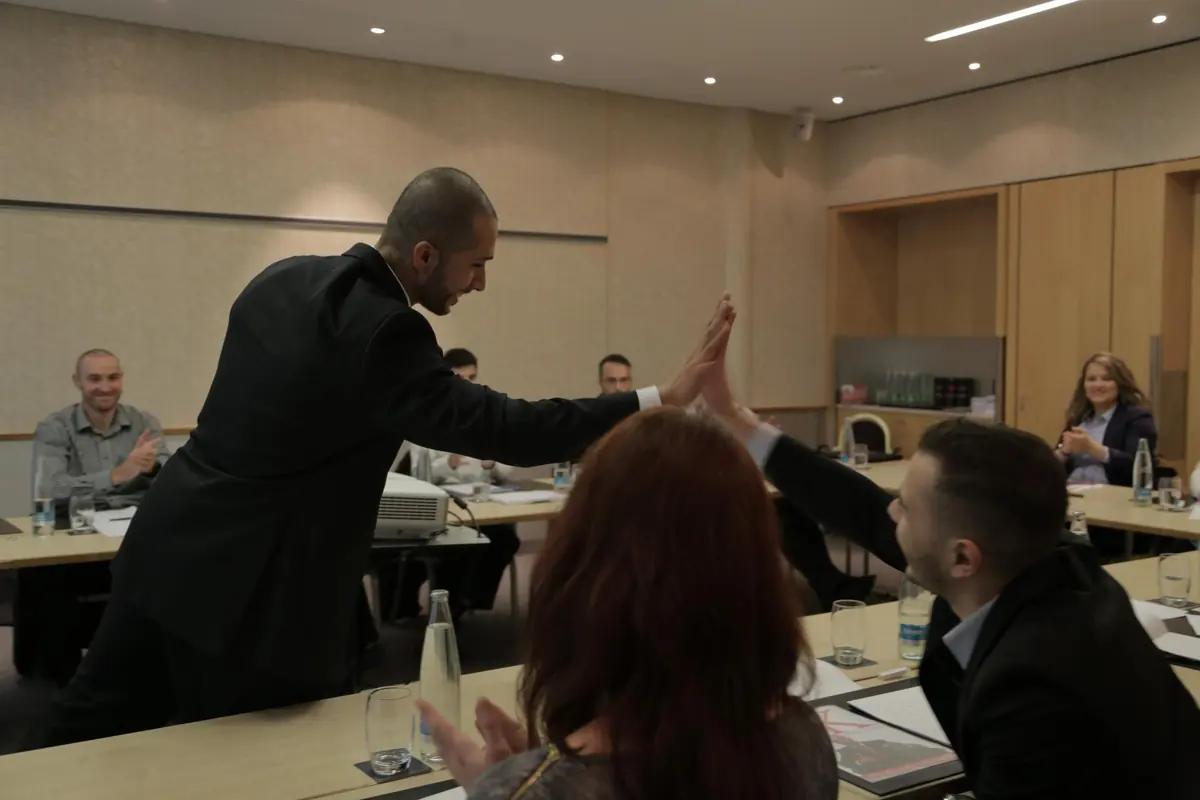 High-five moment during interactive AI coaching workshop demonstrating team building and engagement techniques