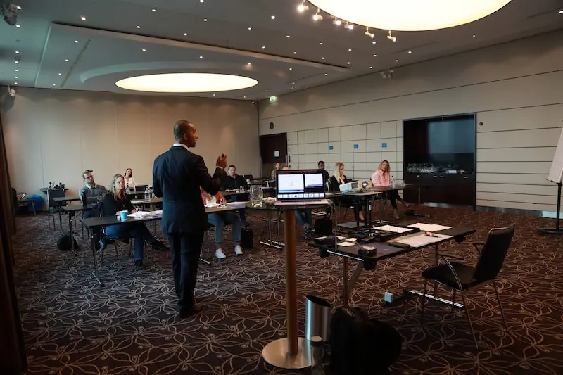 Birol Isik presenting to audience at professional AI consulting and digital marketing conference room