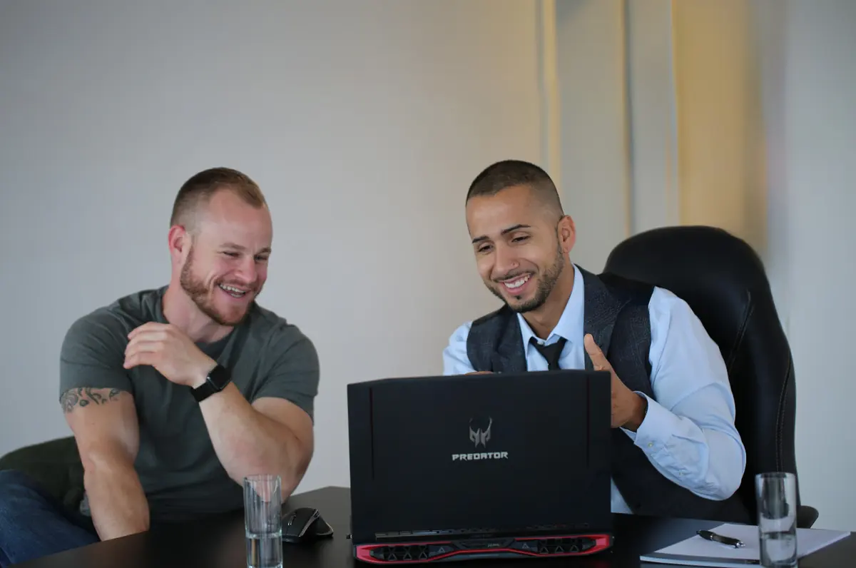 Birol Isik and colleague collaborating on AI strategy at laptop during digital consulting session