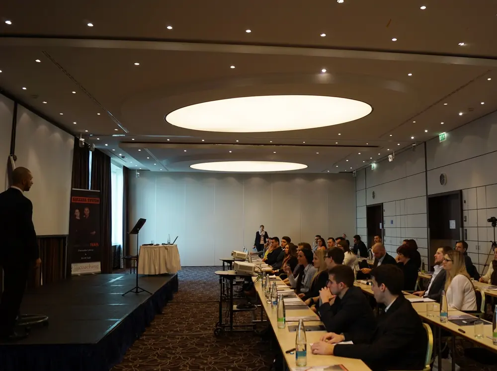 Large seminar room with Birol Isik presenting success system to audience at professional coaching conference